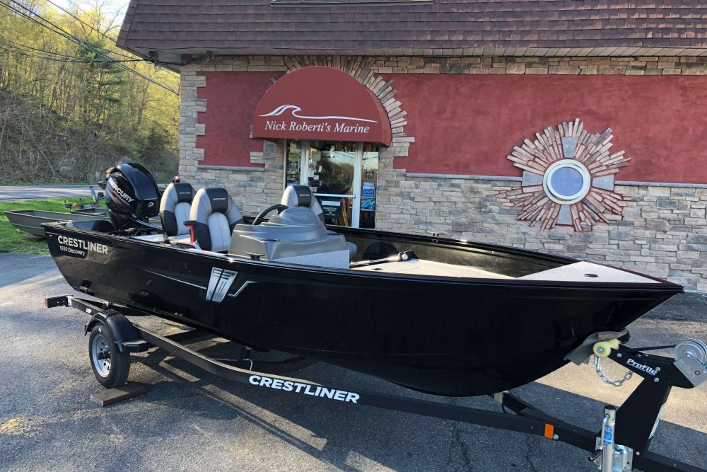 Black boat on trailer in front of store